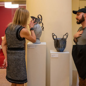 MFA student artist Jonathan Kusnerek discusses his ceramic pieces with Dean Laura Carlson at the Solarium Gallery exhibition 2022: Intersections