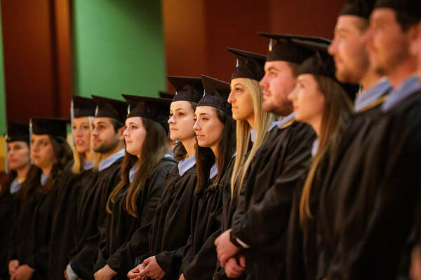 Alliance for Catholic Education graduates dressed in black master's regalia, stand for recognition during the ACE Commencement Ceremony.