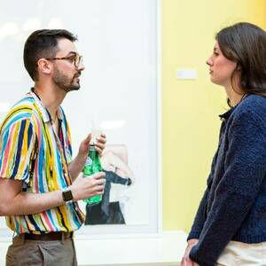 MFA artist Emma Ryan chats with a guest at the Solarium 24 opening reception.
