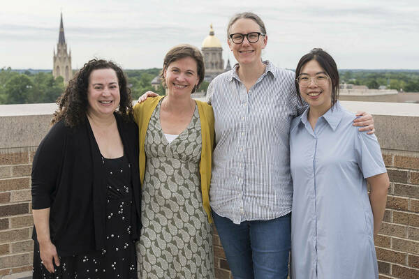 Athena in Action organizers Elizabeth Harman, Elisabeth Camp, Meghan Sullivan, and Sara Chan stand together on a balcony with the Dome and Basilica in the background.
