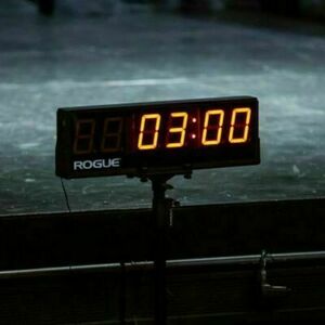 A black Rogue digital timer shows "03:00" in bright orange numbers, set against a dark, textured ice surface.